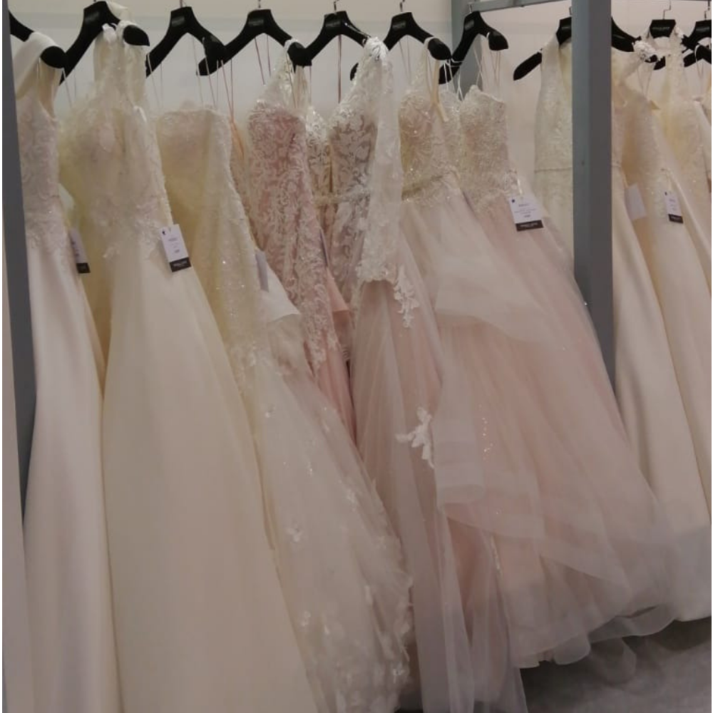 Photo of several wedding dresses hung up in a wedding dress shop 